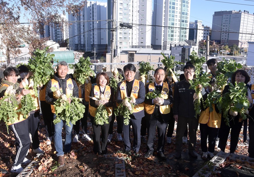 10. 성신고 학생들과 국제라이온스협회 관계자들이 28일 무를 수확하고 기념사진을 찍고있다.jpg