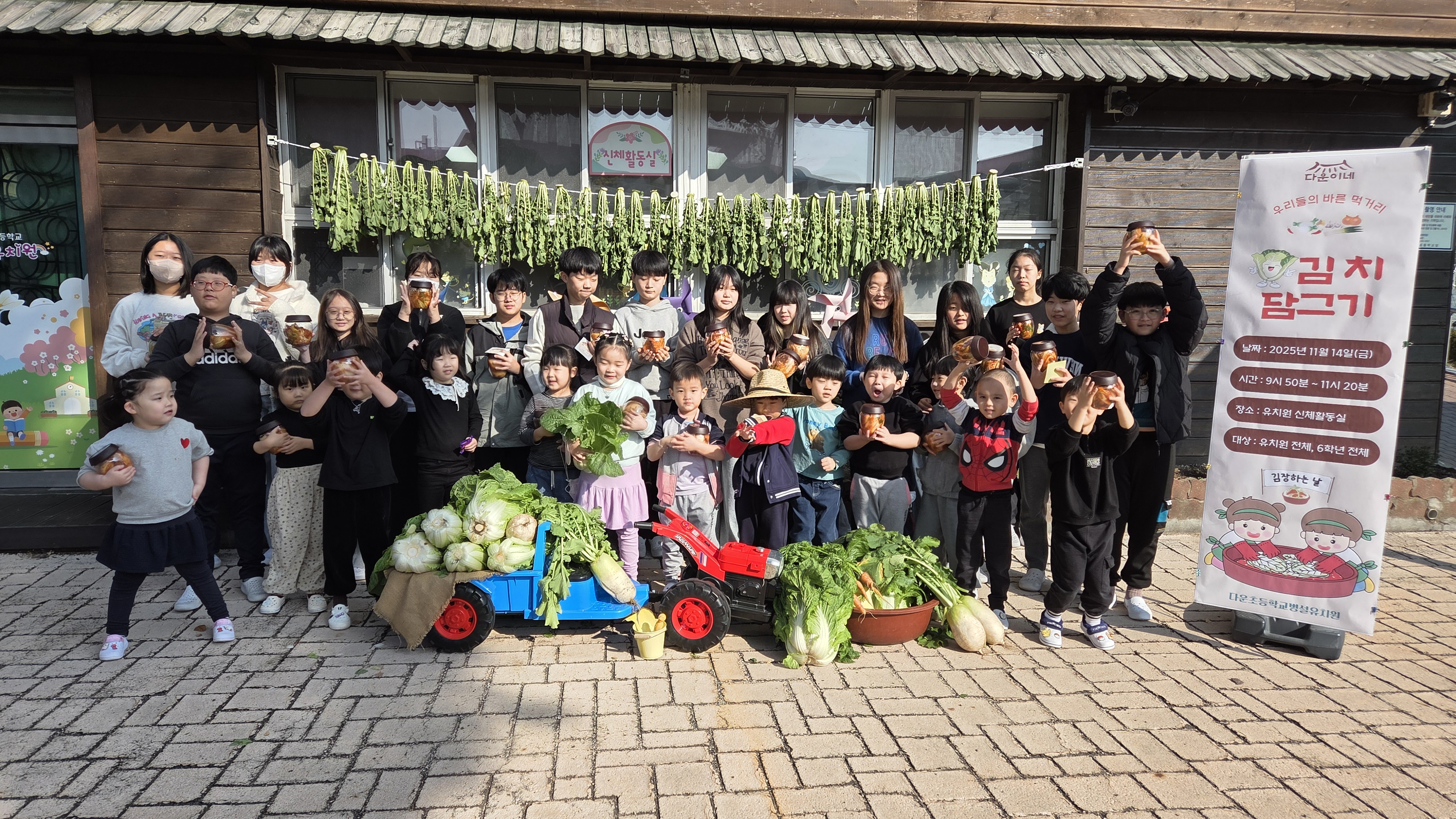 다운초등학교병설유치원 원아들과 초등학교 6학년 학생들이 14일 김장을 담그고 기념사진을 찍고있다.jpg