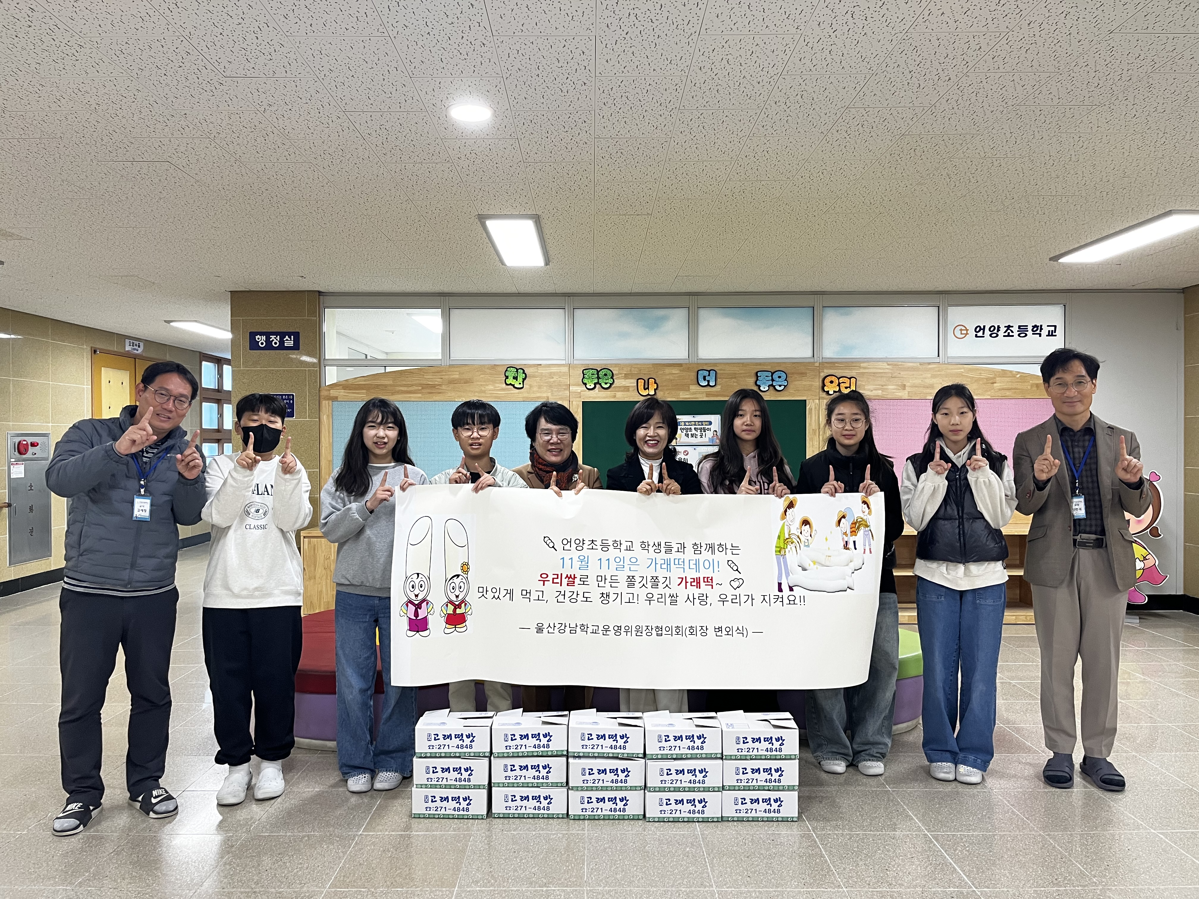 언양초 정기자 교장과 학생들이 11일 강남학교운영위원장 협의회에서 가래떡을 전달받고 기념사진을 찍고있다.jpg