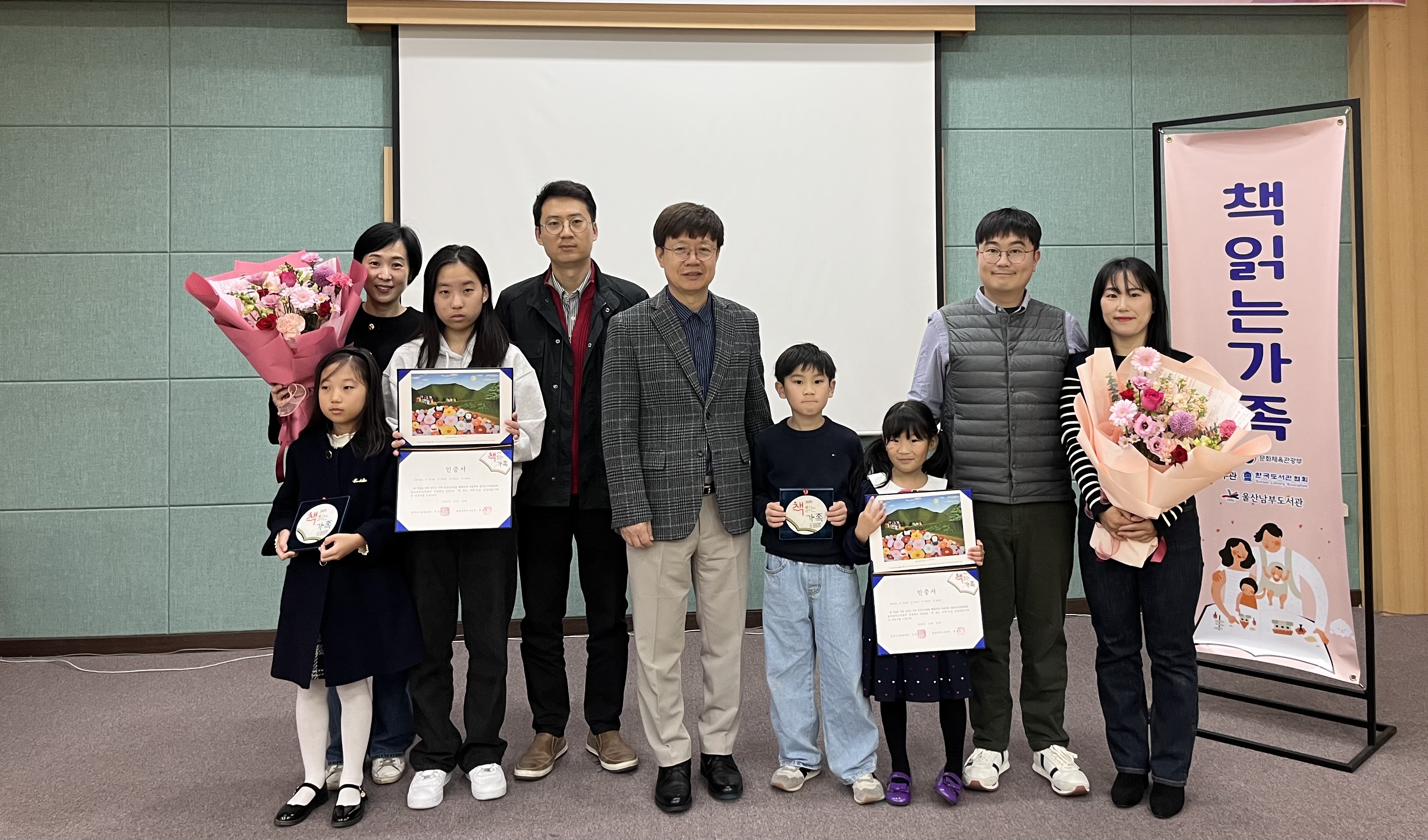 11. 남부도서관 최호동 관장이 15일 진행한 '2025년 책읽는 가족' 시상식에서 선정된 두 가족과 함께 기념사진을 찍고있다.jpg