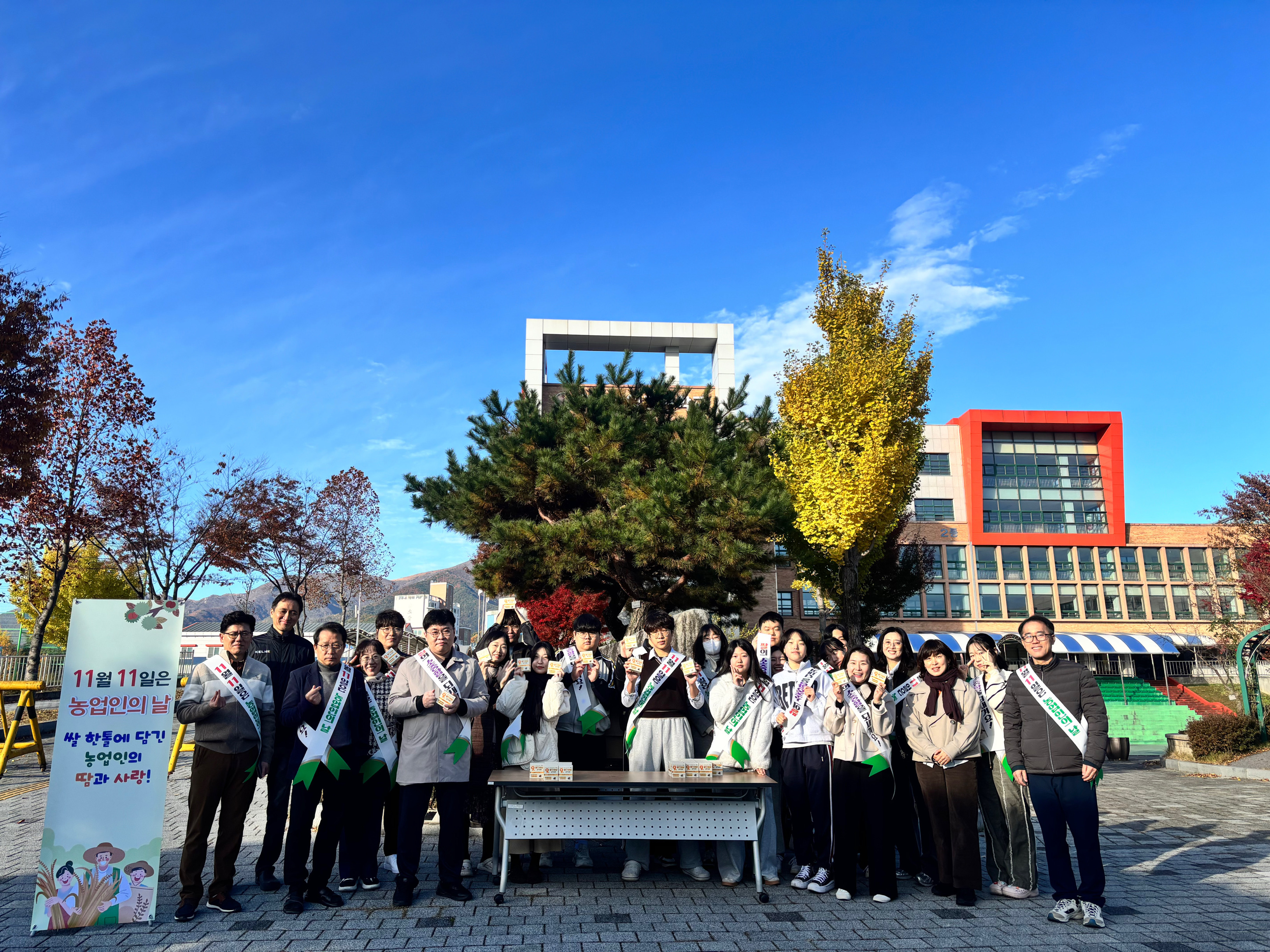 울산산업고 학생들이 11일 농업인의 날을 맞아 삼각 김밥을 나눠 먹고 기념사진을 찍고있다.jpg