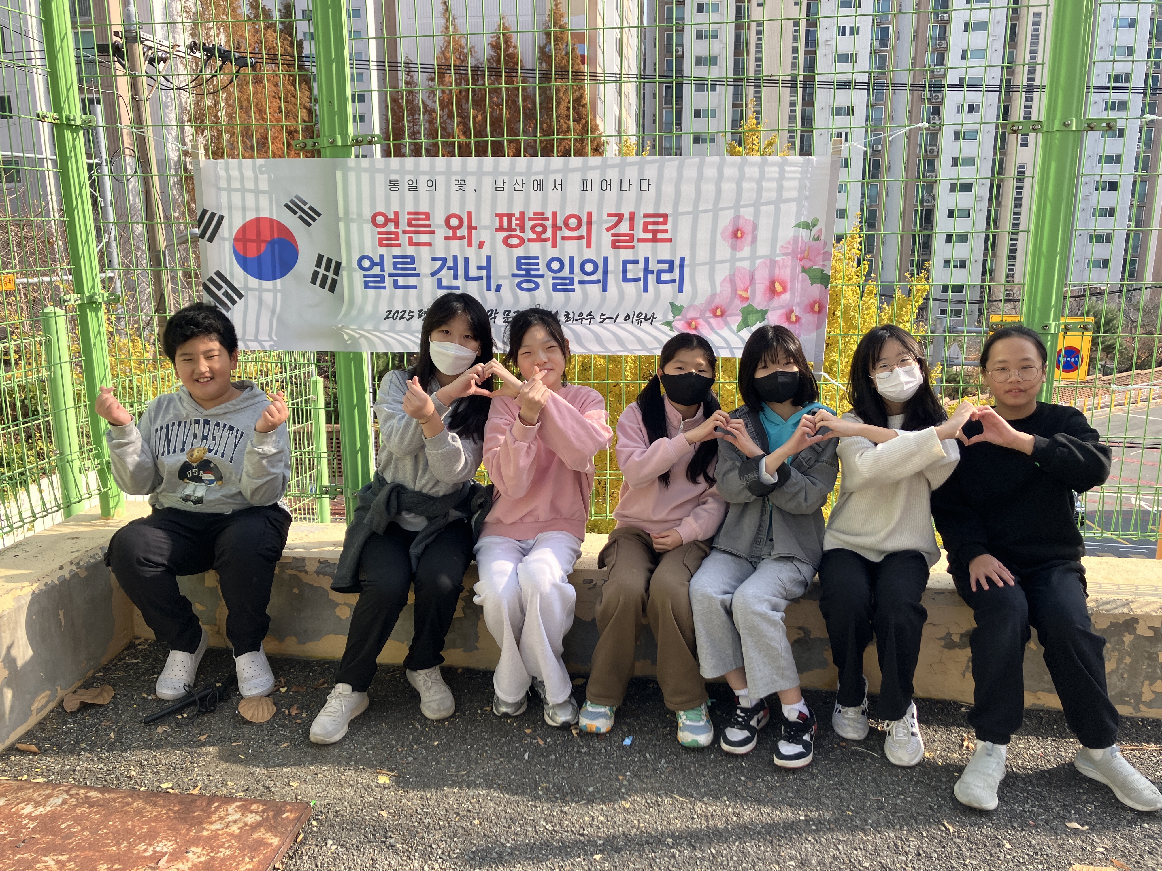 11. 남산초 학생들이 28일 평화 통일교육 주간 현수막 공모전 수상작품 앞에서 기념사진을 찍고있다.JPG