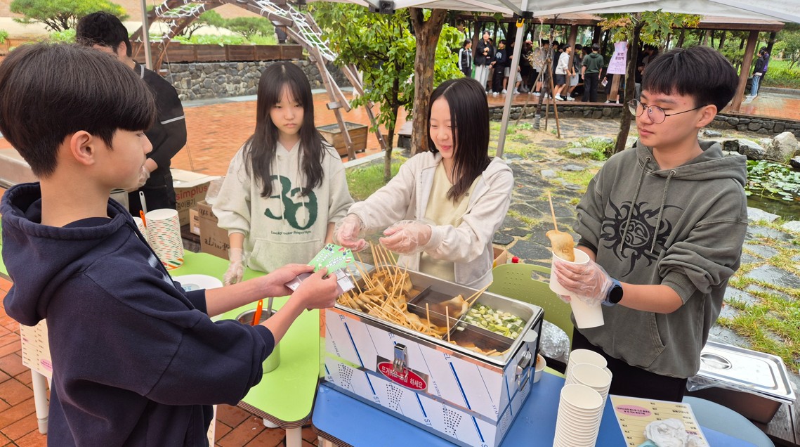 3. 남외중학교 학생들이 22일 임무를 수행하고 얻은  '매점 교환권'으로 먹거리 부스에서 간식을 구매하고 있다.jpg