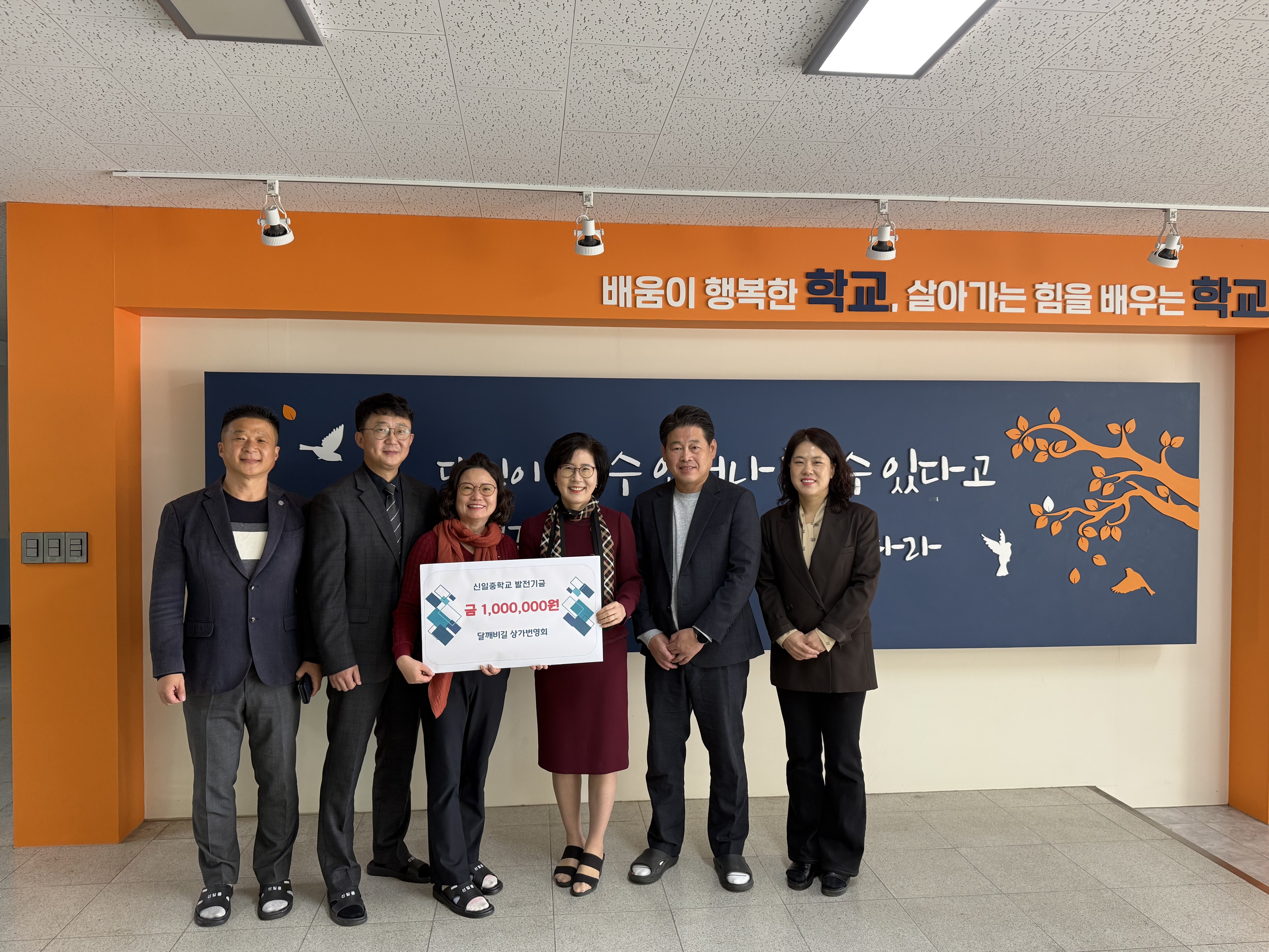 10. 방경애 신일중 교장이 6일 달깨비길 상가번영회에서 발전기금 100만 원을 전달 받고 기념사진을 찍고있다.jpeg