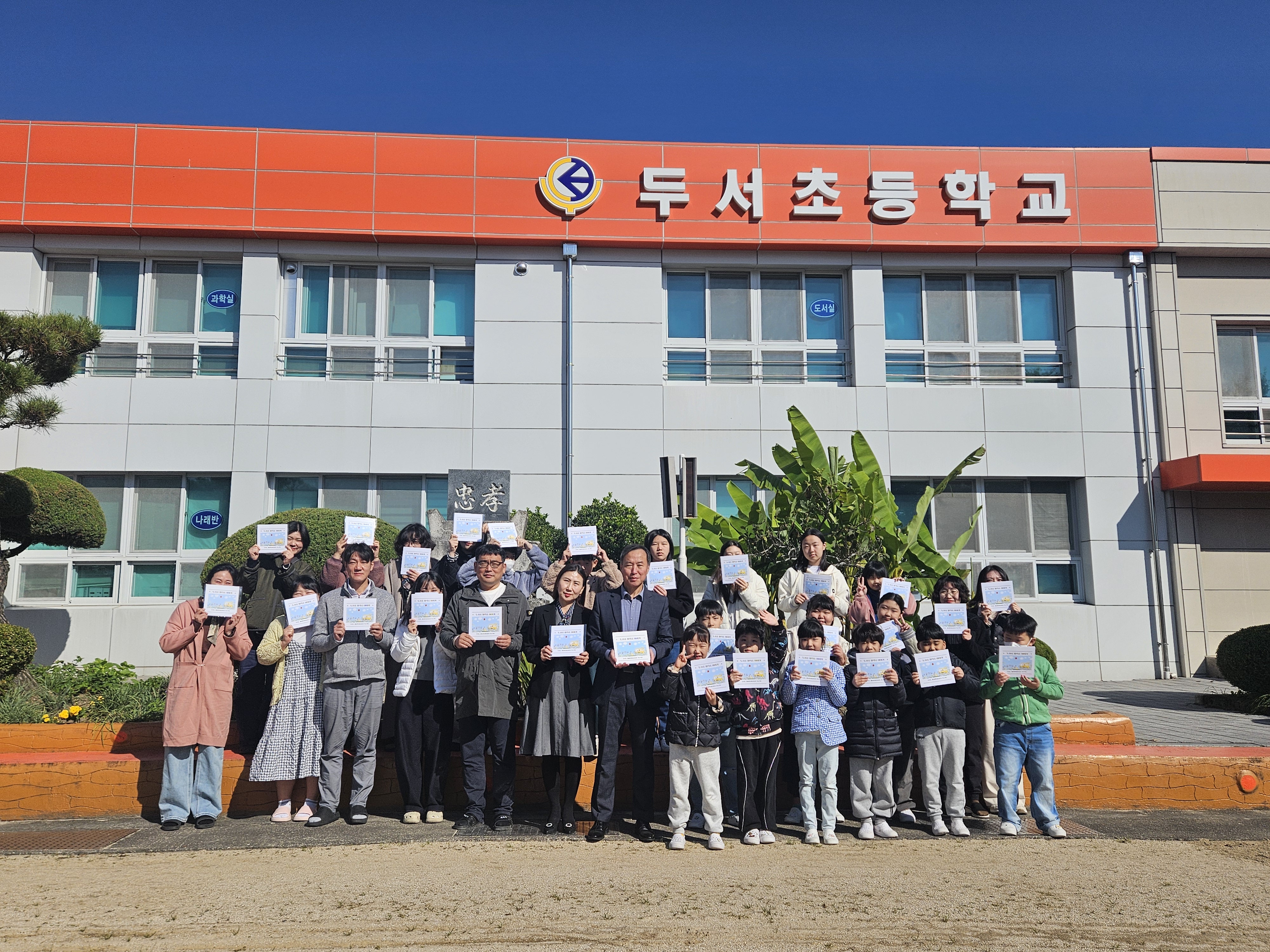 9. 두서초등학교 학생들이 29일 '활력소 마을 화가 운영사례집'을 받고 기념촬영을 하고있다.jpg