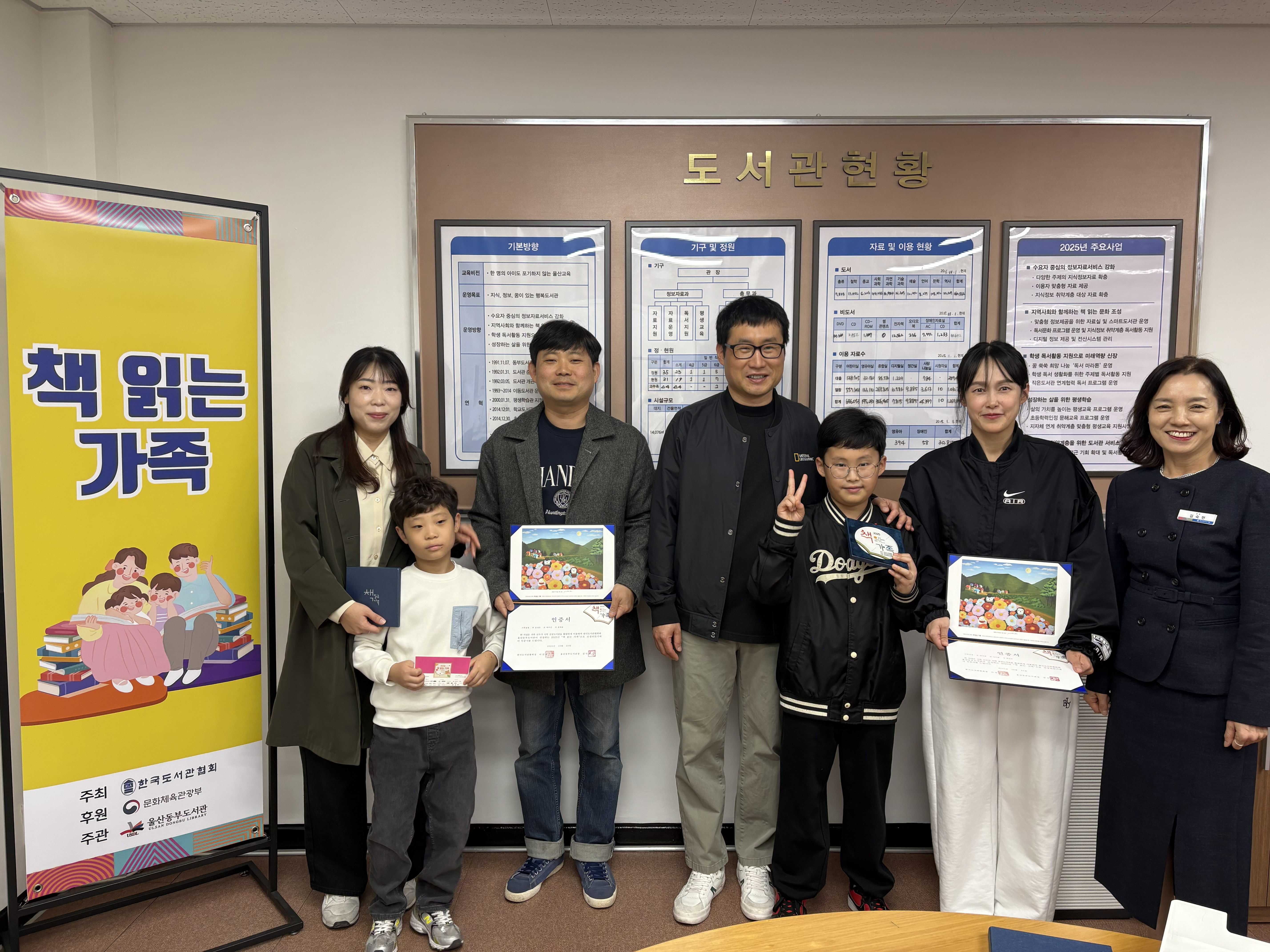 11. 동부도서관 김숙현 관장이 15일 진행한 '2025년 책읽는 가족' 시상식에서 선정된 두 가족과 함께 기념사진을 찍고있다.jpg