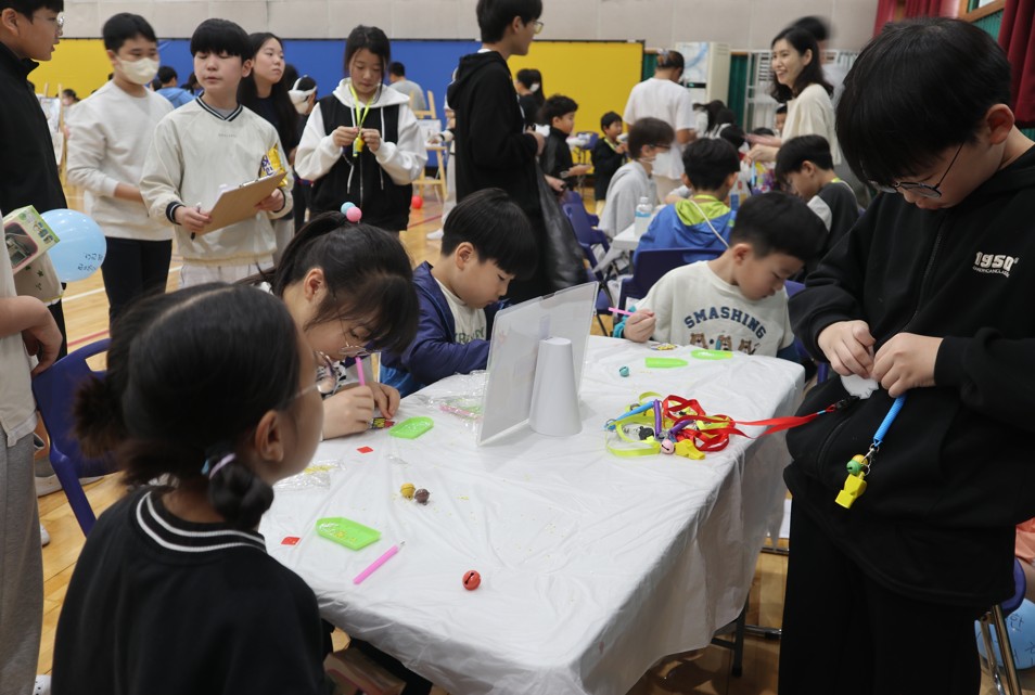 8. 남산초 학생들이 21일 '남산 안전 축제'에서 열 수축 플라스틱 종이 공예(슈링클스)체험을 하고있다.JPG