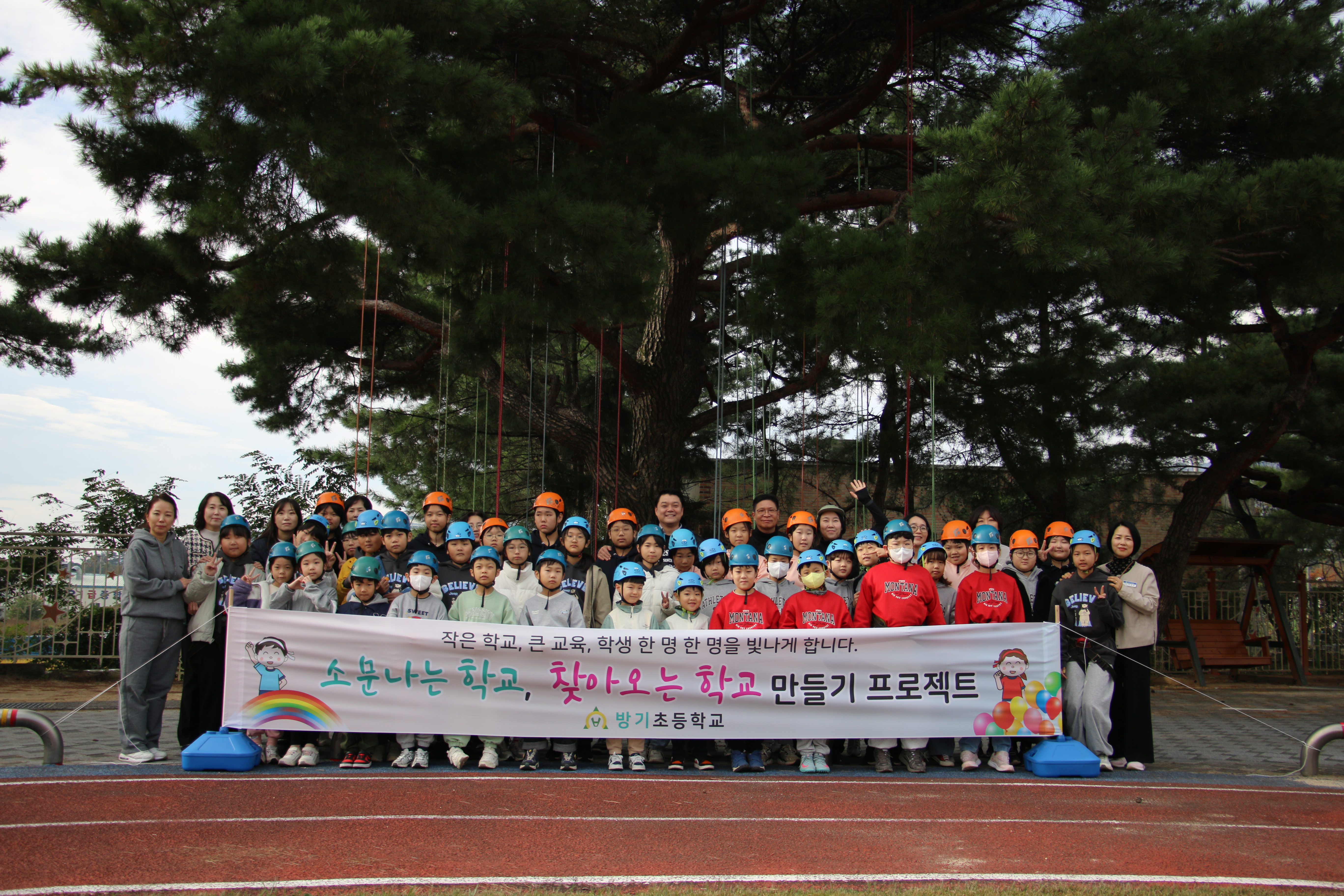 방기초등학교 학생들이 31일 학교 숲에서 트리 클라이밍과 짚라인 체험을 하고 단체사진을 찍고있다.JPG