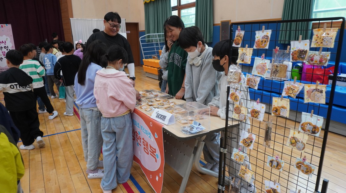 9. 영화초등학교 학생들이 23일 체육관에서 열린 '비즈미켓'에 참여해 매장 상품을 구매하고 있다.JPG