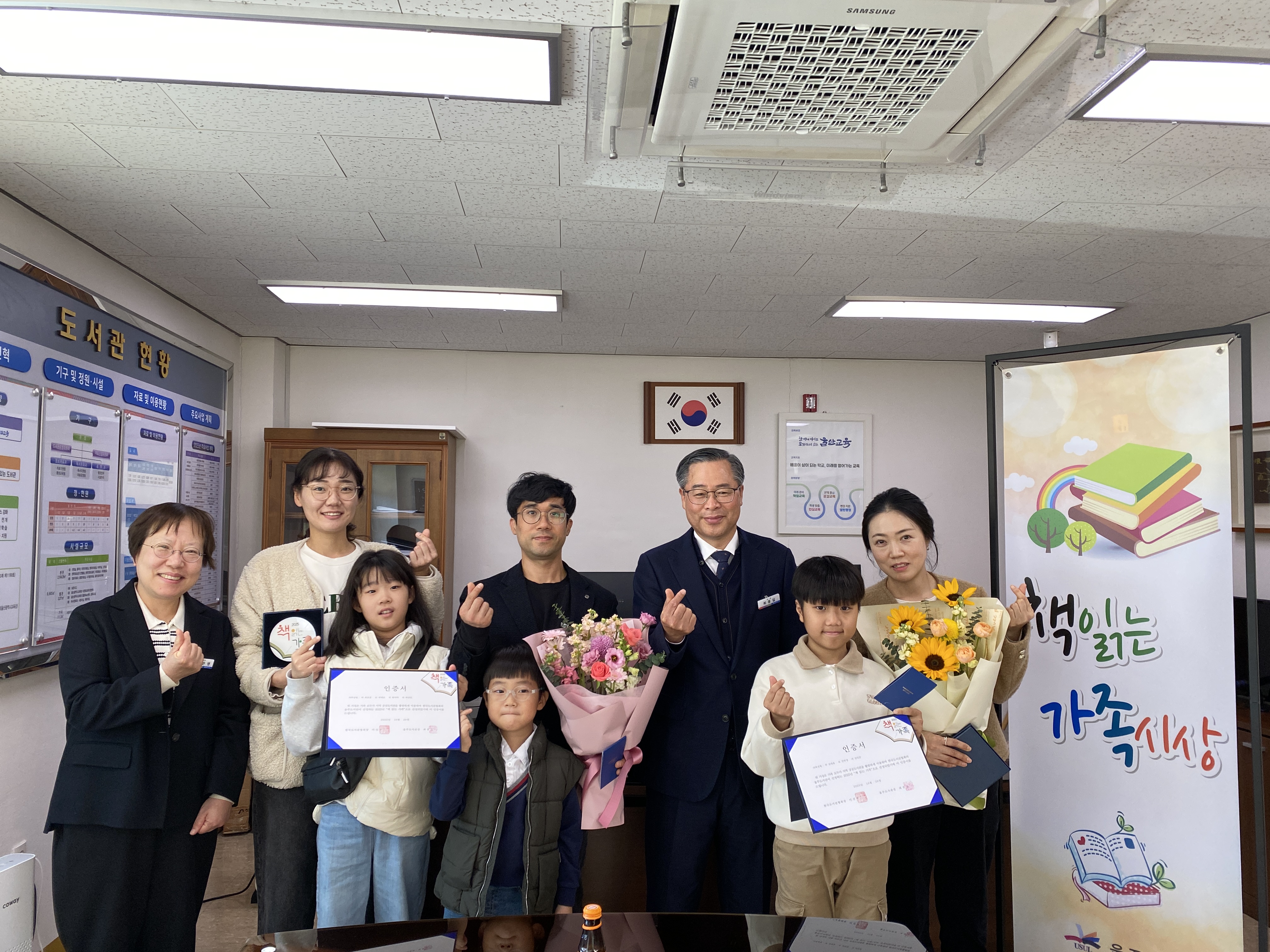 11. 울주도서관 최종길 관장이 15일 진행한 '2025년 책읽는 가족' 시상식에서 선정된 두 가족과 함께 기념사진을 찍고있다.JPG