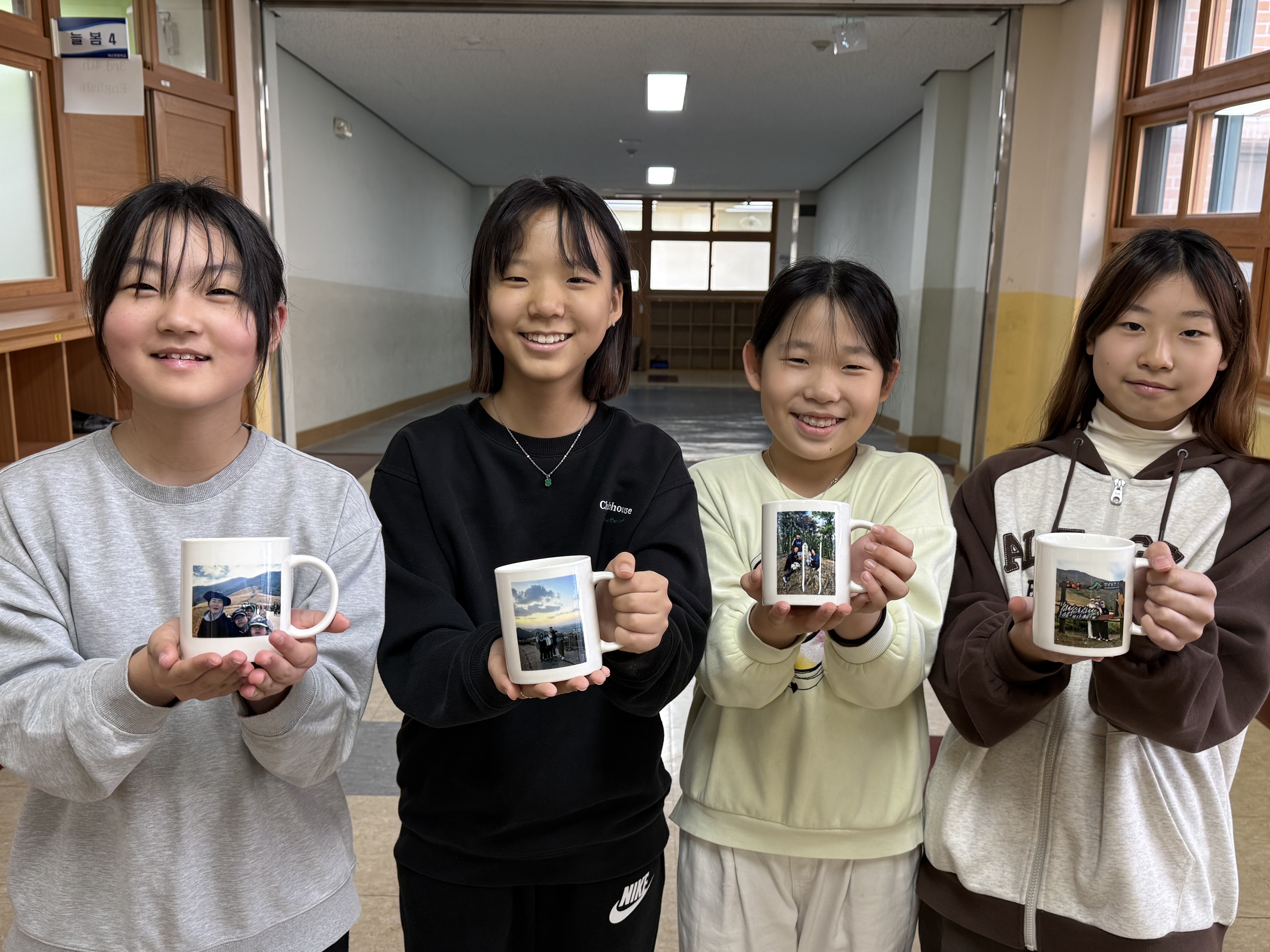 매산초 학생들이 가족과 함께 등반한 인증사진이 있는 통컵을 들고 기념사진을 찍고있다 .jpg