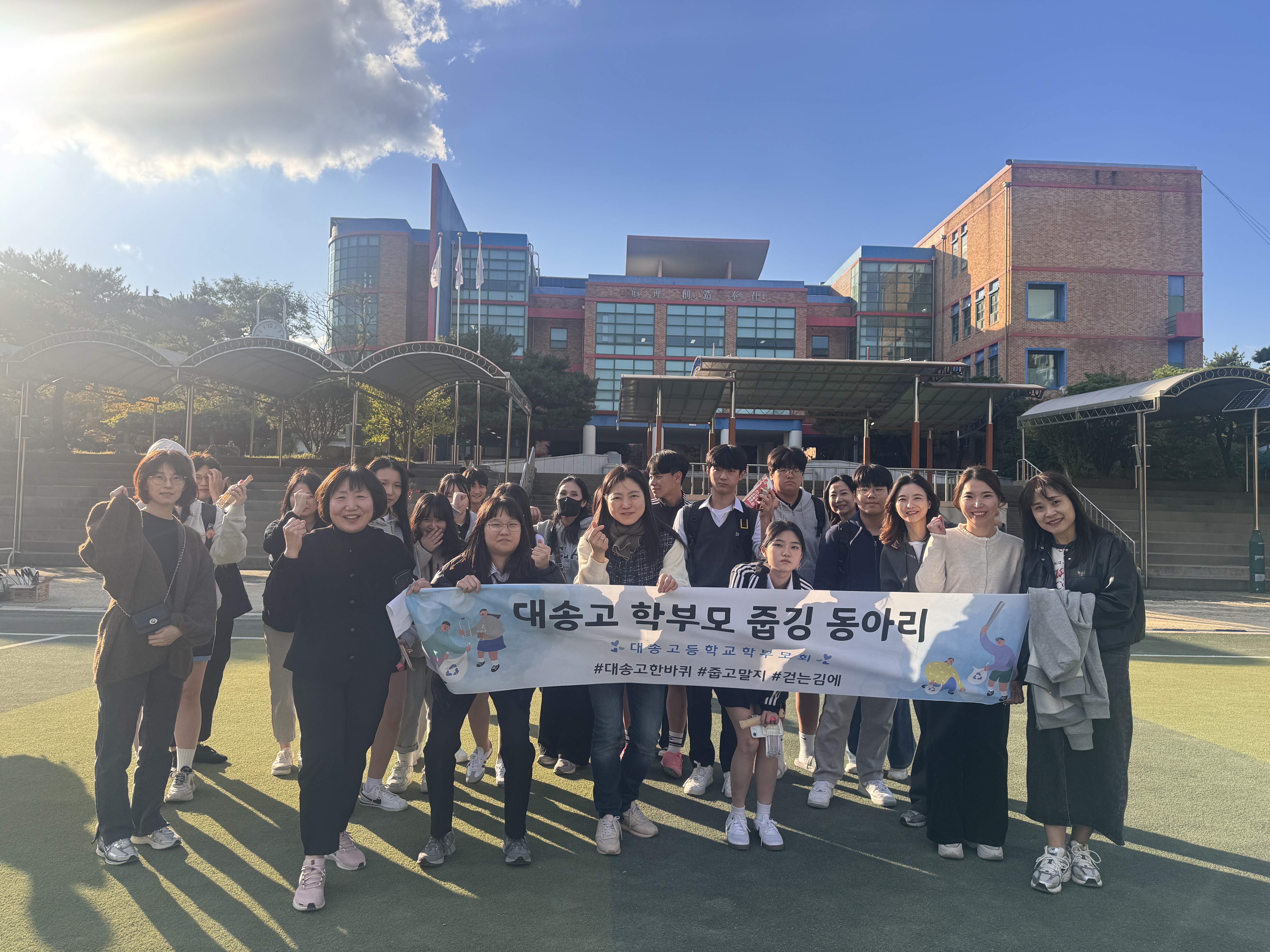 대송고등학교 학생과 학부모들이 19일 학교 인근에서 '줍깅' 활동을 하고 기념사진을 찍고있다.jpg