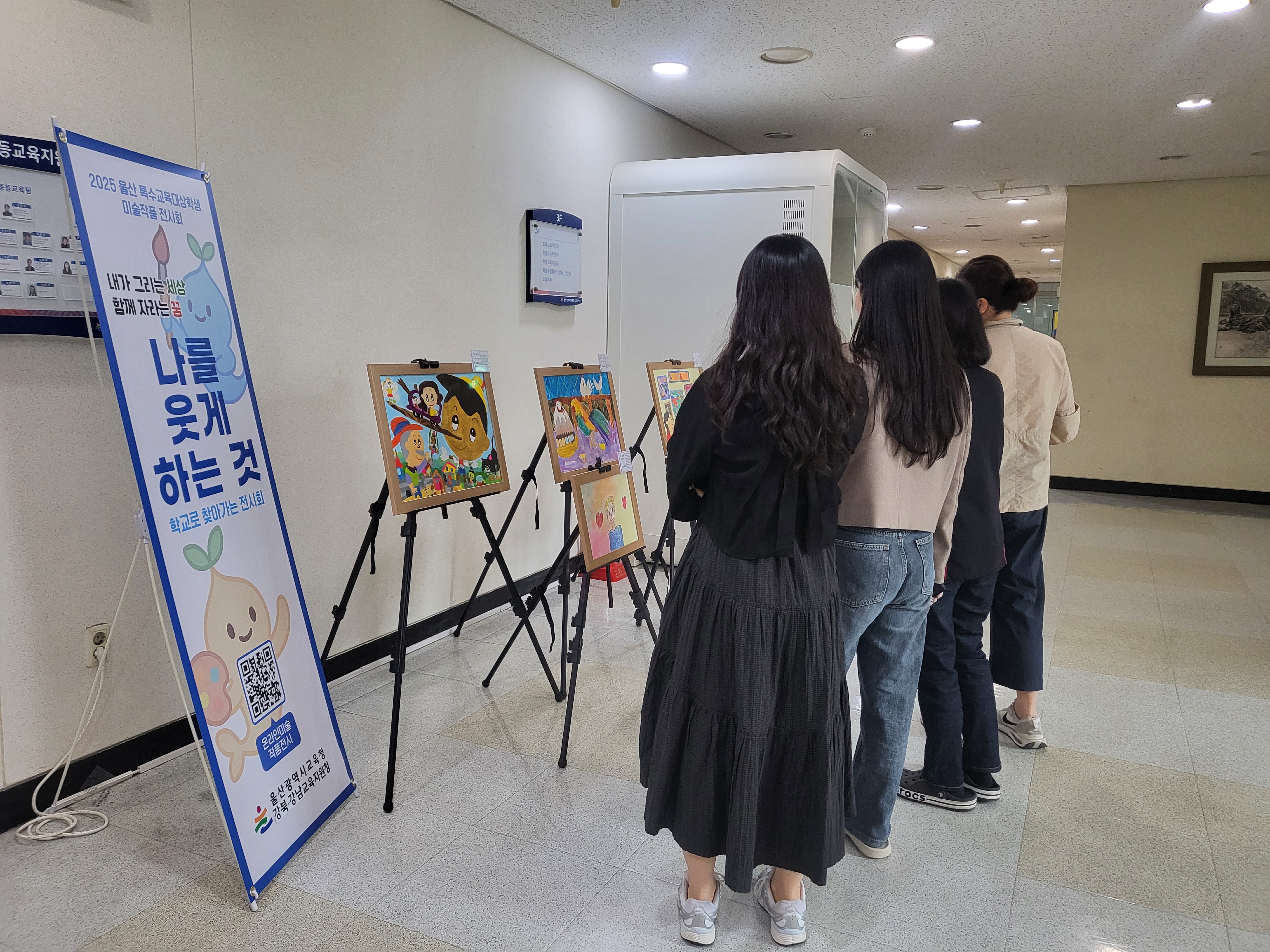 6. 강북교유지원청 직원들이 지난 16일 청사 내 전시된 장애 학생 작품을 감상하고 있다 (2).jpg